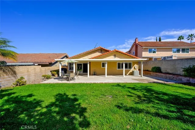 a view of a house with a yard and large tree