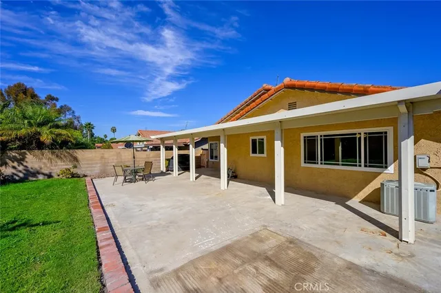 a patio with a table and chairs under an umbrella