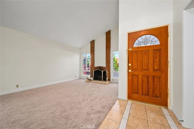 a view of an empty room with a fireplace and a window