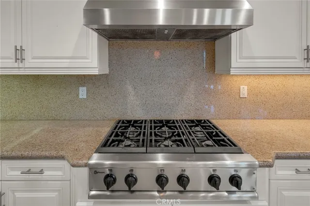 a kitchen with a sink a counter top space cabinets and stainless steel appliances