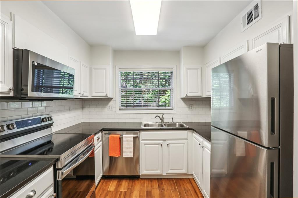 311 Peachtree Hills Avenue Northeast, Unit 13B Atlanta, GA 30305 - Photo 17 of 30 a kitchen with granite countertop a refrigerator stove and sink