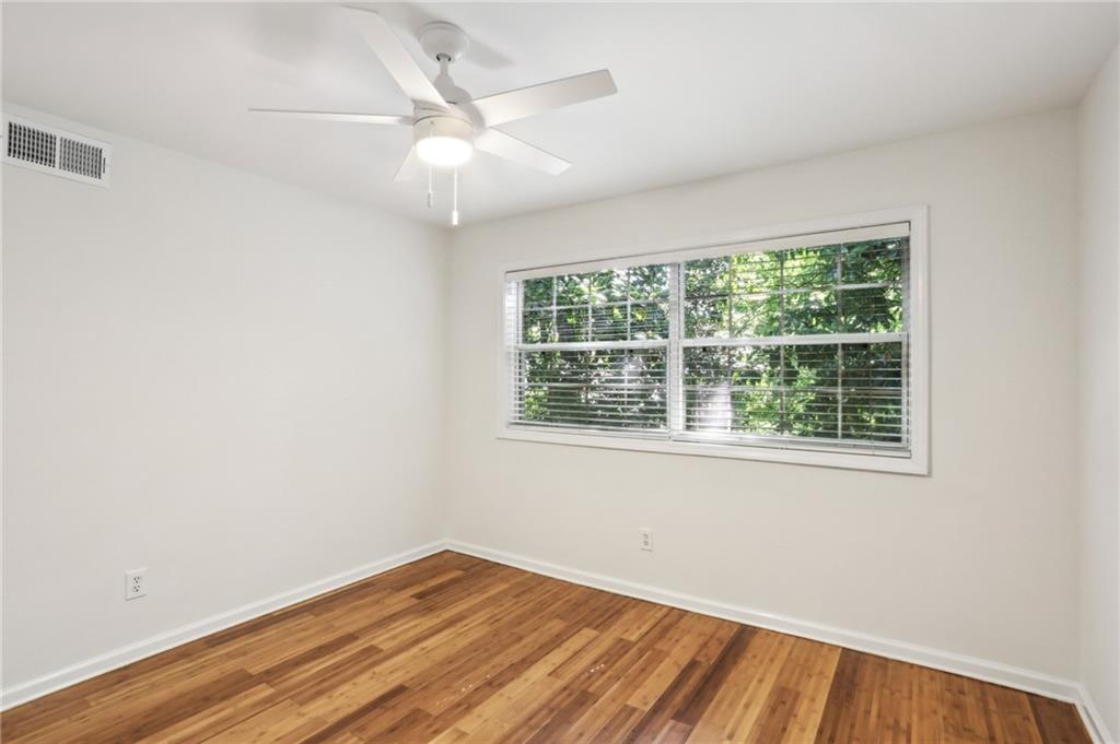 311 Peachtree Hills Avenue Northeast, Unit 13B Atlanta, GA 30305 - Photo 21 of 30 an empty room with wooden floor and windows