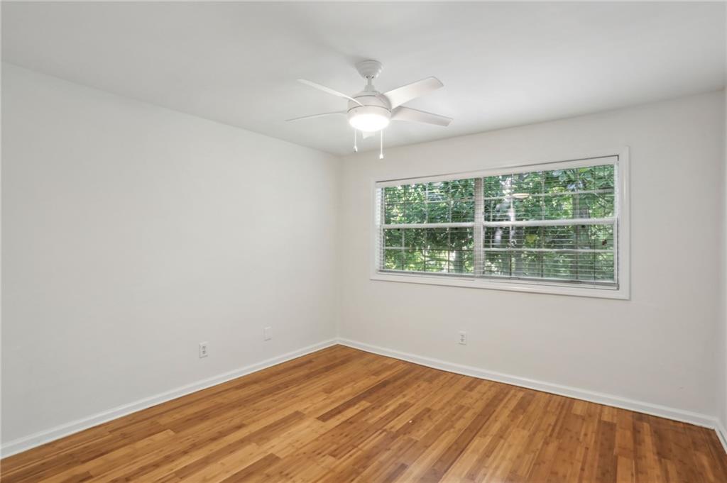 311 Peachtree Hills Avenue Northeast, Unit 13B Atlanta, GA 30305 - Photo 22 of 30 an empty room with wooden floor and windows