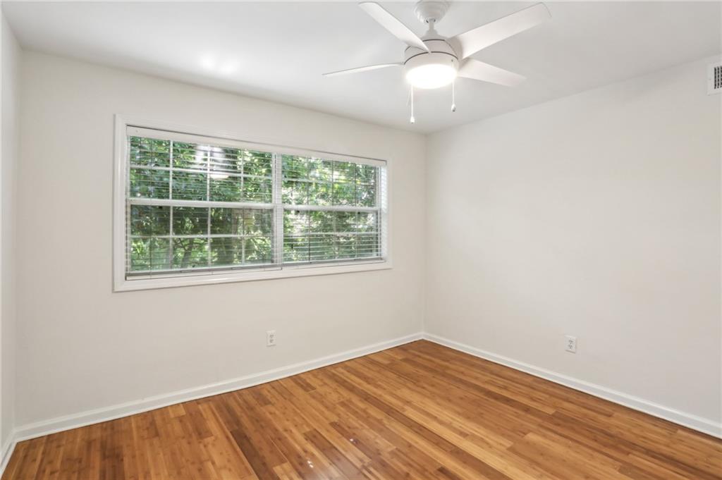 311 Peachtree Hills Avenue Northeast, Unit 13B Atlanta, GA 30305 - Photo 24 of 30 an empty room with a window and wooden floor