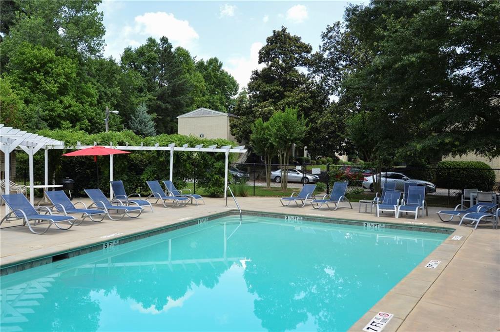 311 Peachtree Hills Avenue Northeast, Unit 13B Atlanta, GA 30305 - Photo 28 of 30 a view of a swimming pool with chairs and table