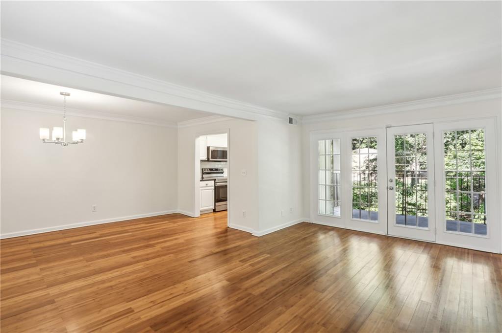 311 Peachtree Hills Avenue Northeast, Unit 13B Atlanta, GA 30305 - Photo 8 of 30 an empty room with wooden floor and windows