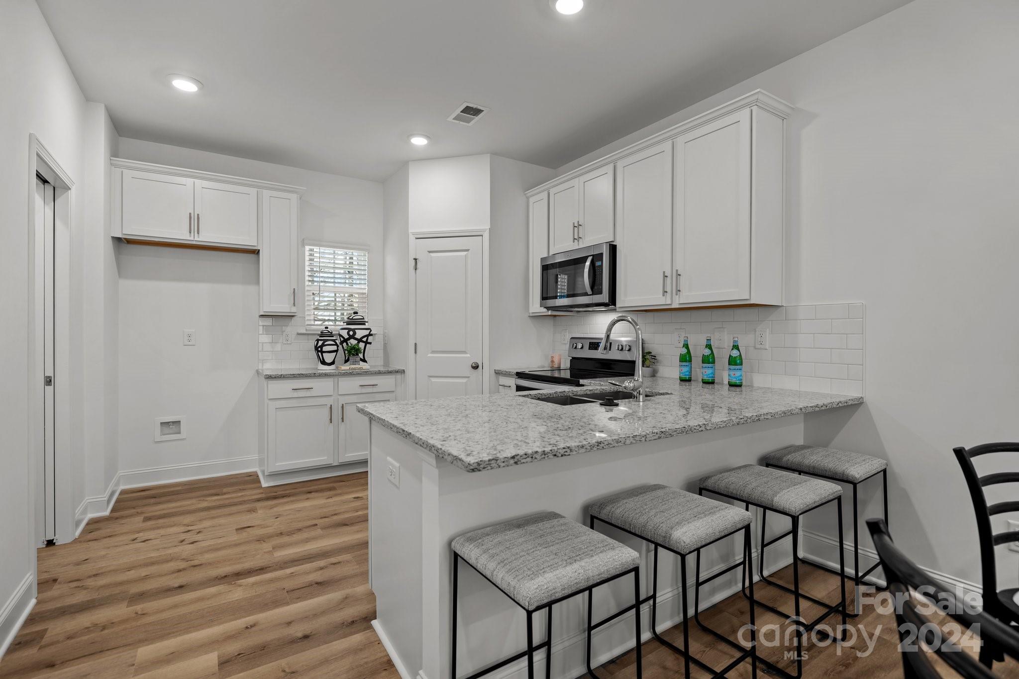3018 Butler Hl Drive Matthews, NC 28105 - Photo 6 of 20 a kitchen with granite countertop white cabinets and stainless steel appliances