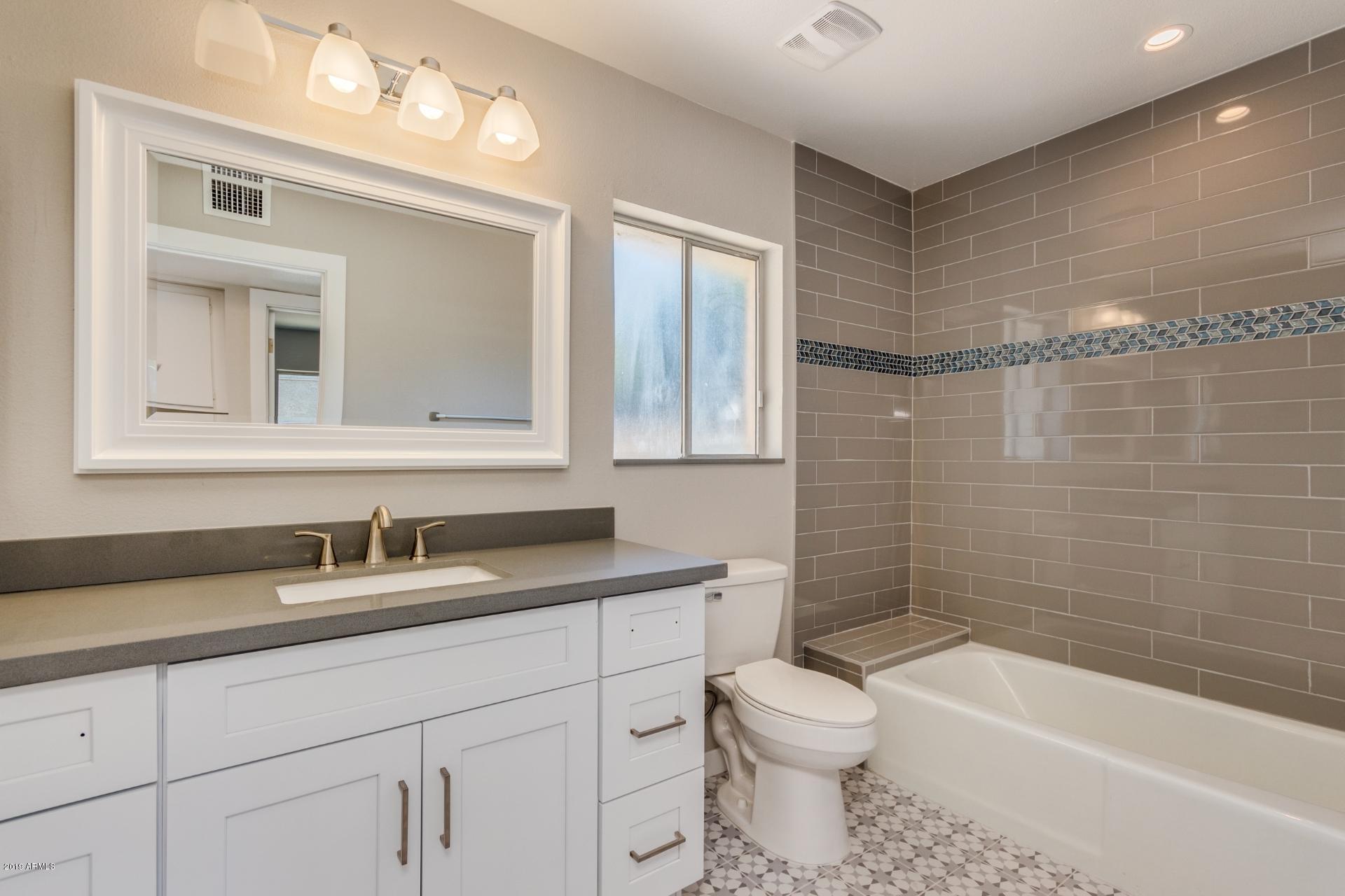 5503 South Rocky Point Road Tempe, AZ 85283 - Photo 16 of 22 a bathroom with a toilet a sink a mirror a bathtub and vanity