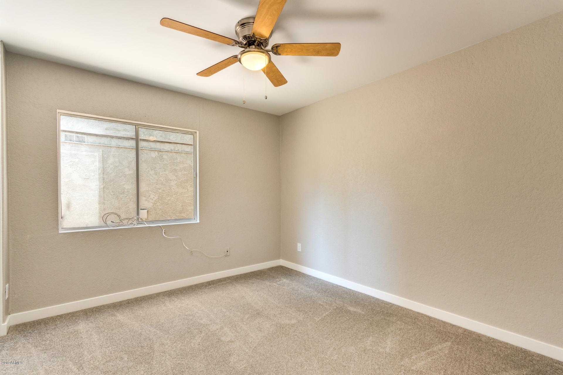 5503 South Rocky Point Road Tempe, AZ 85283 - Photo 17 of 22 an empty room with a window and a fan