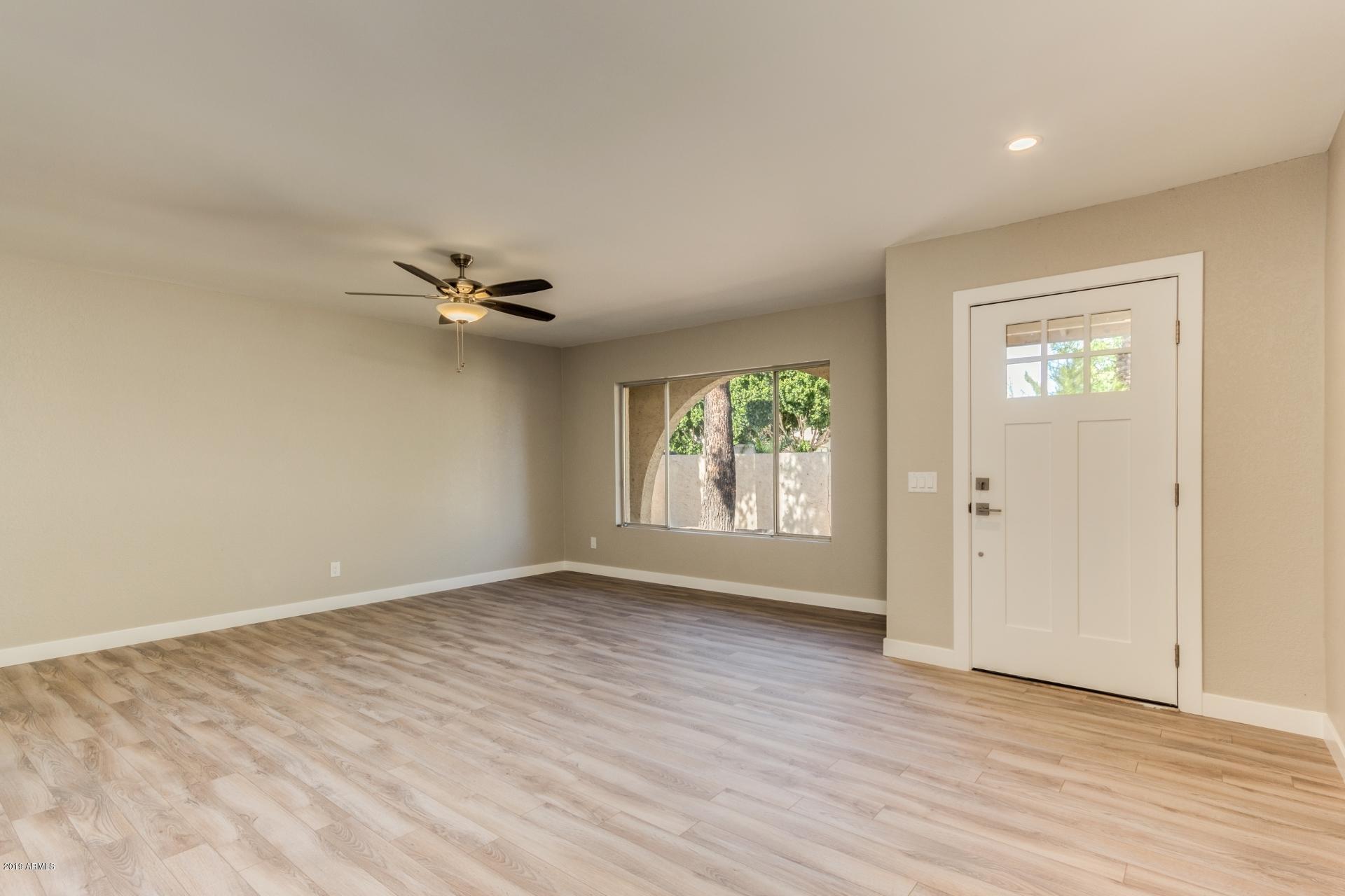5503 South Rocky Point Road Tempe, AZ 85283 - Photo 5 of 22 a view of an empty room with wooden floor and a window