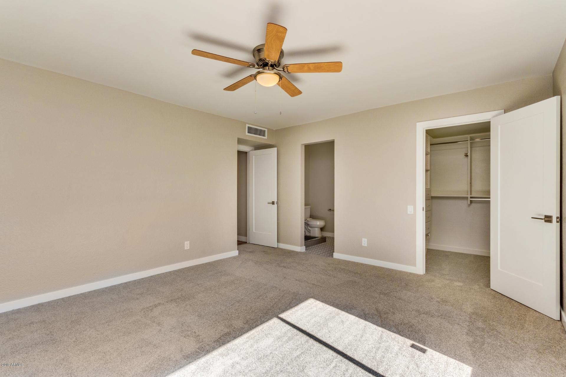 5503 South Rocky Point Road Tempe, AZ 85283 - Photo 8 of 22 a view of a livingroom with a ceiling fan and wooden floor