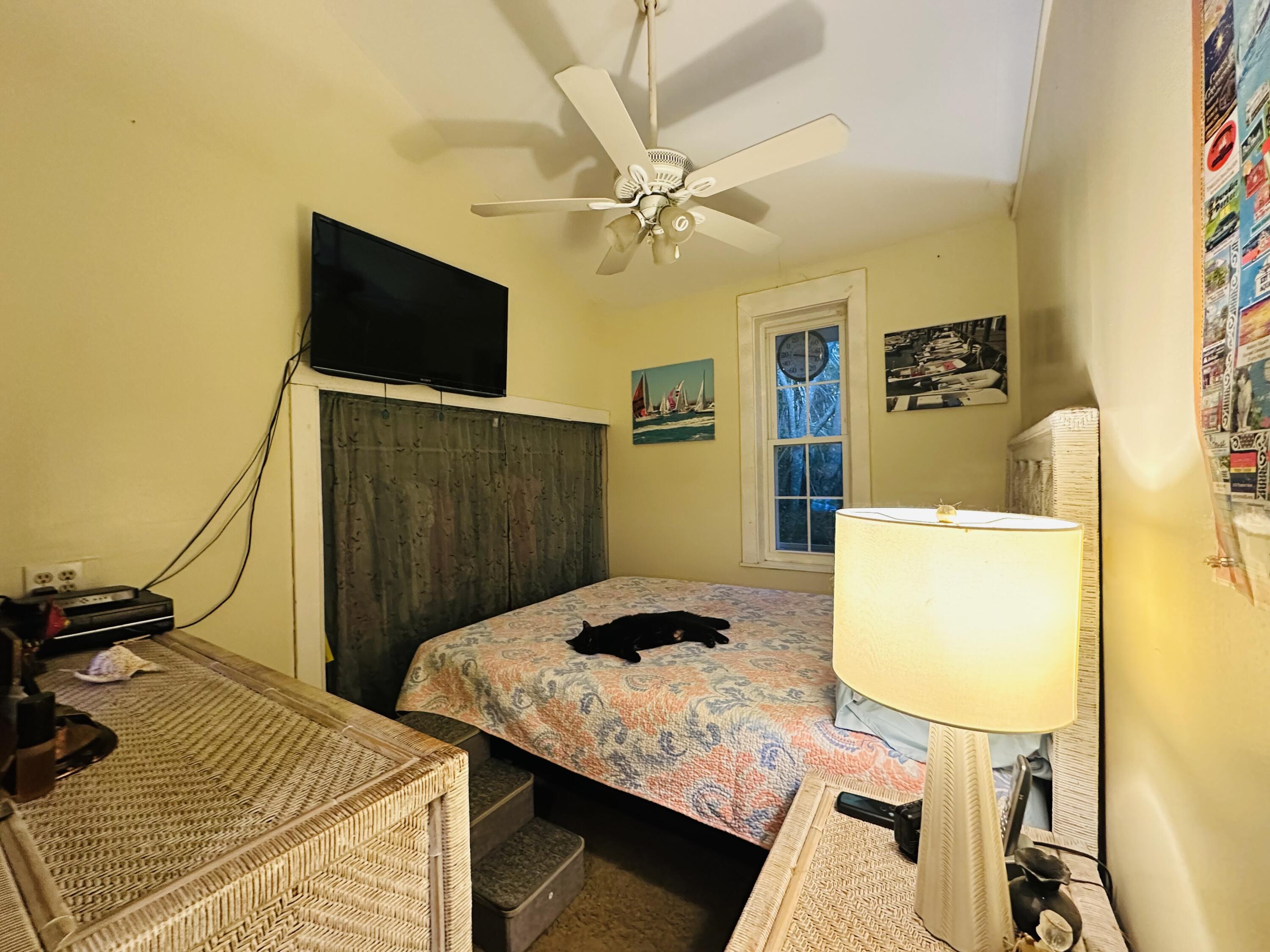 21857 Disturbed Pine Road Cudjoe, FL 33042 - Photo 21 of 30 a bedroom with a bed and a flat screen tv