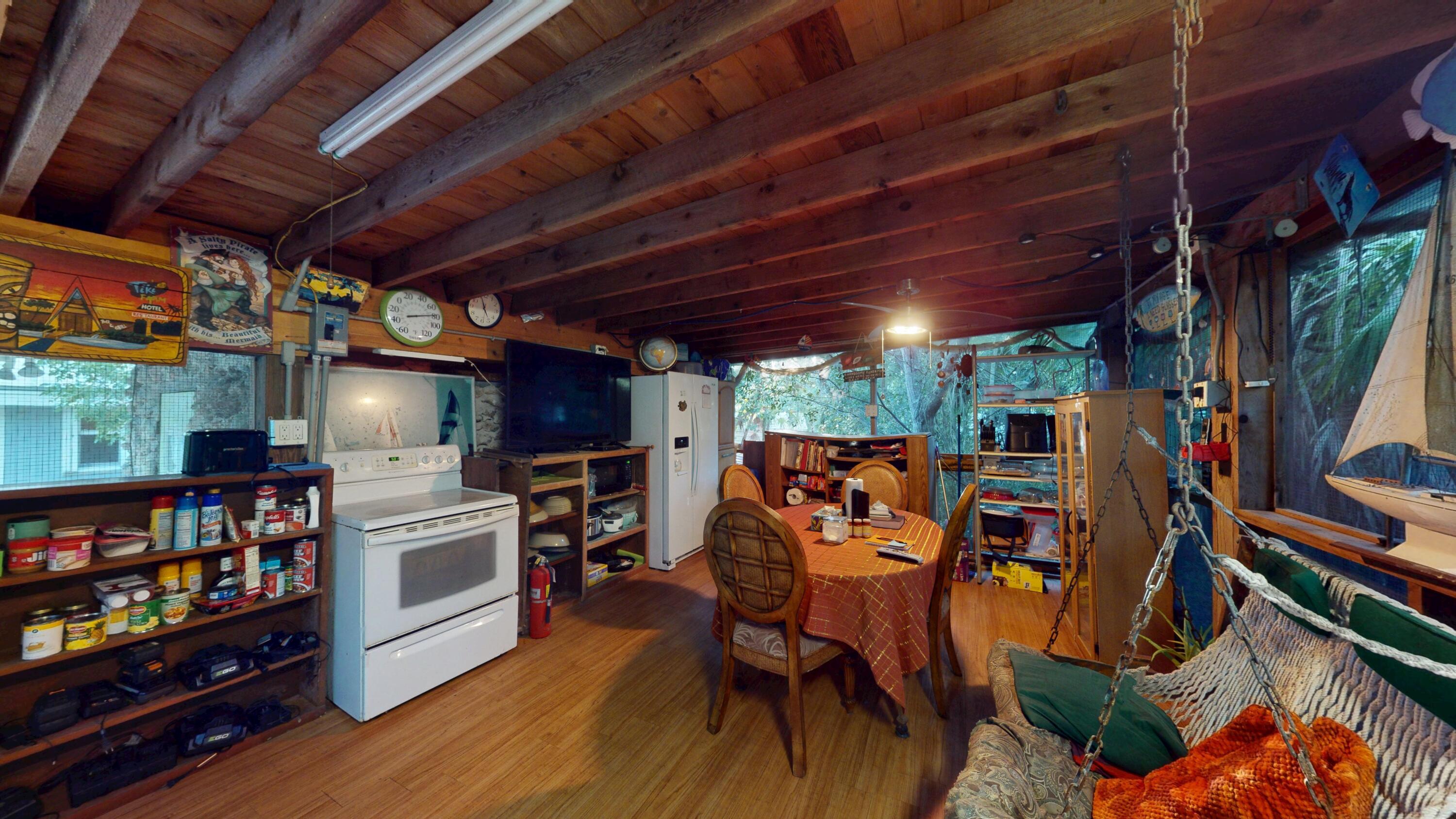 21857 Disturbed Pine Road Cudjoe, FL 33042 - Photo 5 of 31 a view of a room with lots of wooden furniture and a flat screen tv
