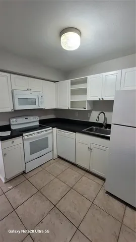 a white kitchen with a sink and cabinets