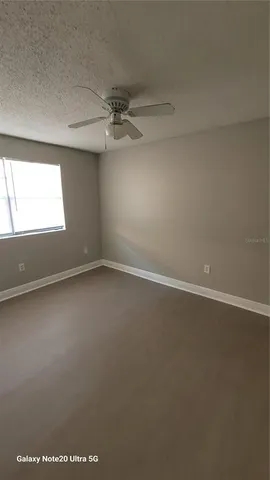 an empty room with a windows and ceiling fan
