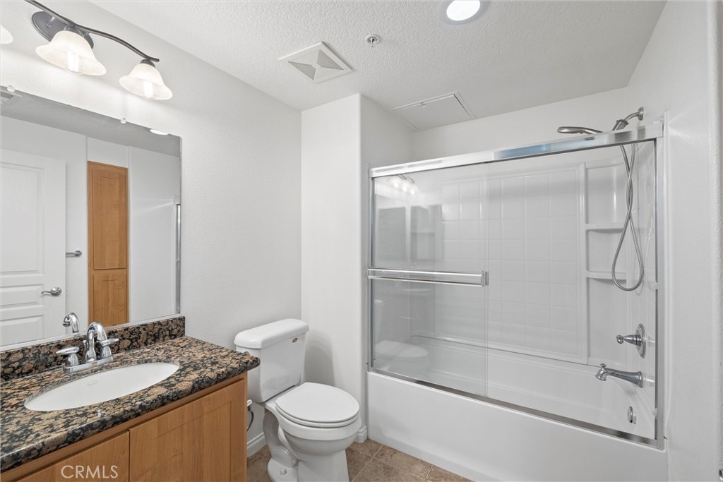 12688 Chapman Avenue, Unit 3201 Garden Grove, CA 92840 - Photo 11 of 17 a bathroom with a granite countertop sink toilet and shower