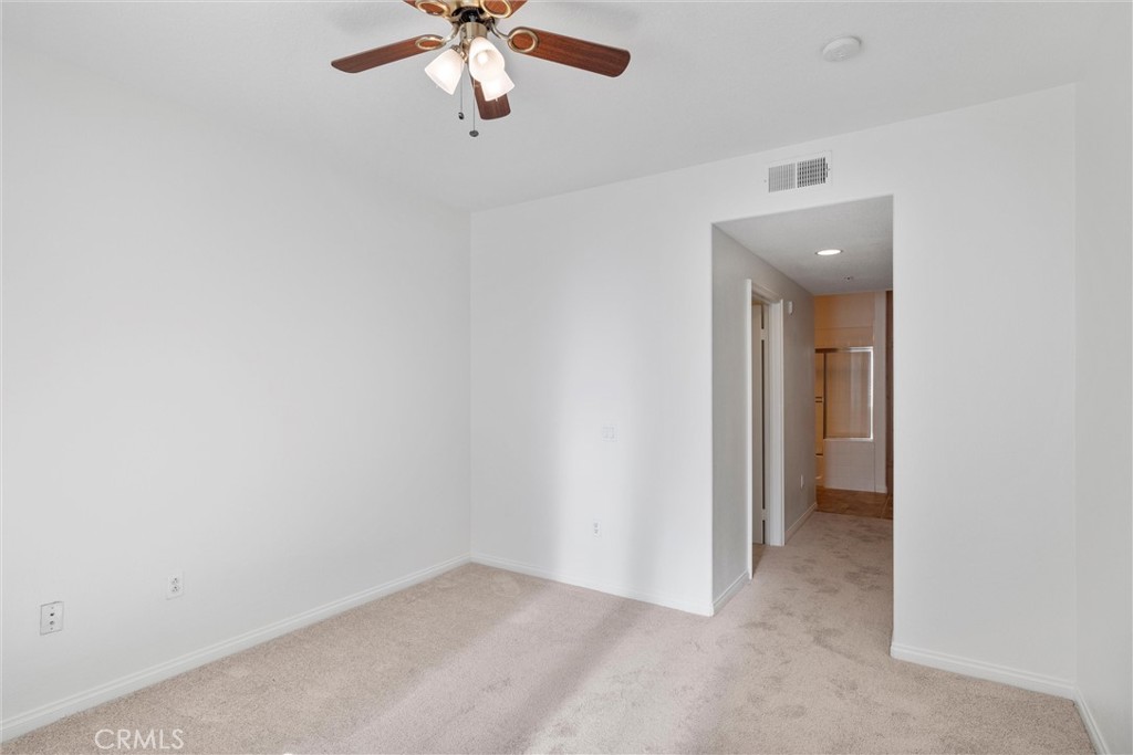 12688 Chapman Avenue, Unit 3201 Garden Grove, CA 92840 - Photo 13 of 17 an empty room with a chandelier fan and a window