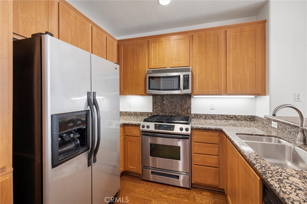 12688 Chapman Avenue, Unit 3201 Garden Grove, CA 92840 - Photo 2 of 17 a kitchen with a stove a sink and a refrigerator
