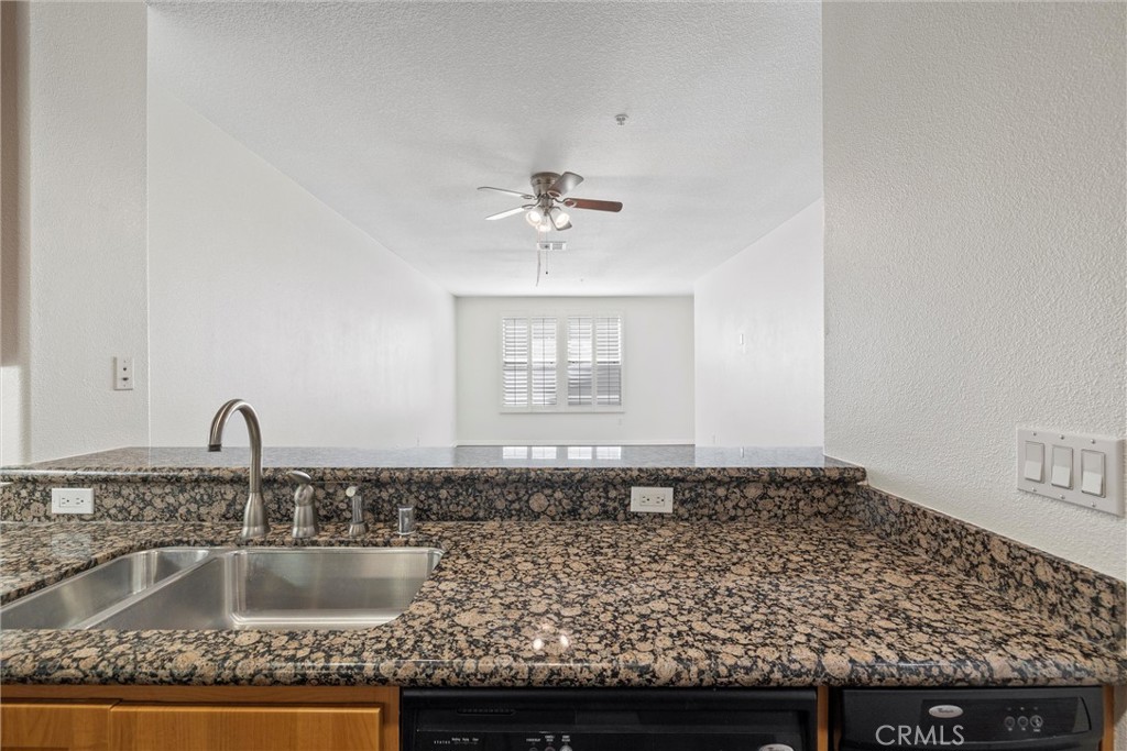 12688 Chapman Avenue, Unit 3201 Garden Grove, CA 92840 - Photo 5 of 17 a kitchen with granite countertop a sink and white cabinets