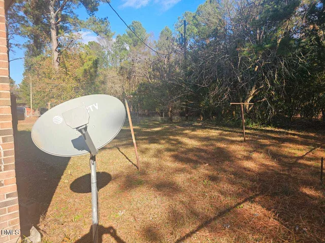 a backyard of a house with table and chairs