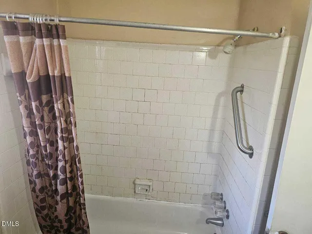 a bathroom with a shower curtain and a shower