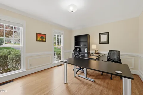 a view of a workspace with furniture and a window