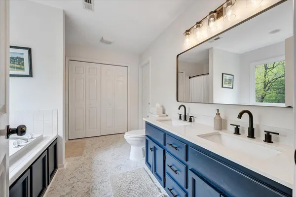a spacious bathroom with a double vanity sink and mirror