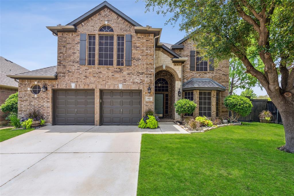 a front view of a house with garden and trees