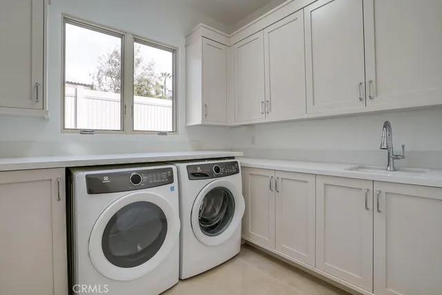 a utility room with sink dryer and washer