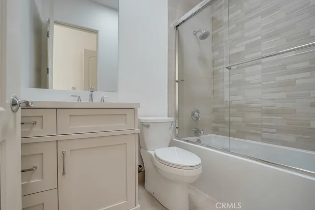 a bathroom with a toilet a sink a mirror and shower