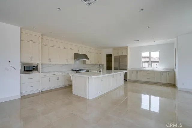 a large white kitchen with cabinets