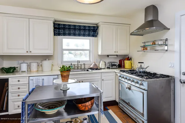 a kitchen with a stove a sink and a window