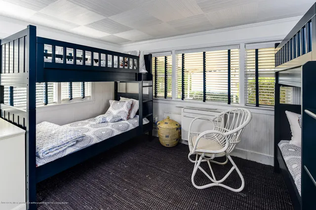 a bedroom with a bed and windows