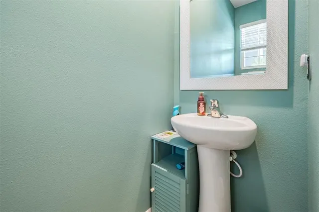 a bathroom with a granite countertop sink toilet mirror and bathtub