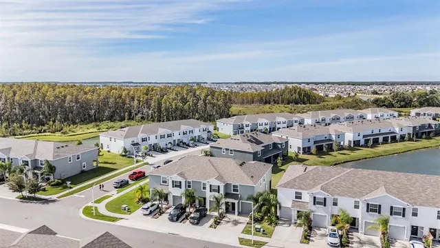 an aerial view of a swimming pool with a yard and outdoor seating
