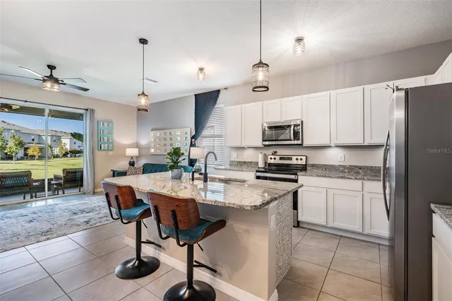 a kitchen with a sink a counter top space appliances and cabinets