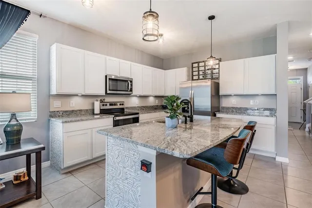 a living room with chairs and kitchen view