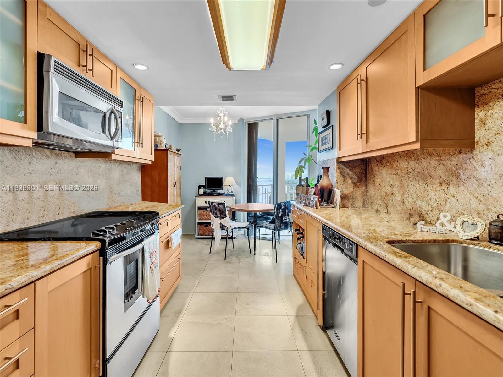2000 Towerside Terrace, Unit 1806 Miami, FL 33138 - Photo 35 of 58 a kitchen with stainless steel appliances granite countertop a stove a sink and a microwave