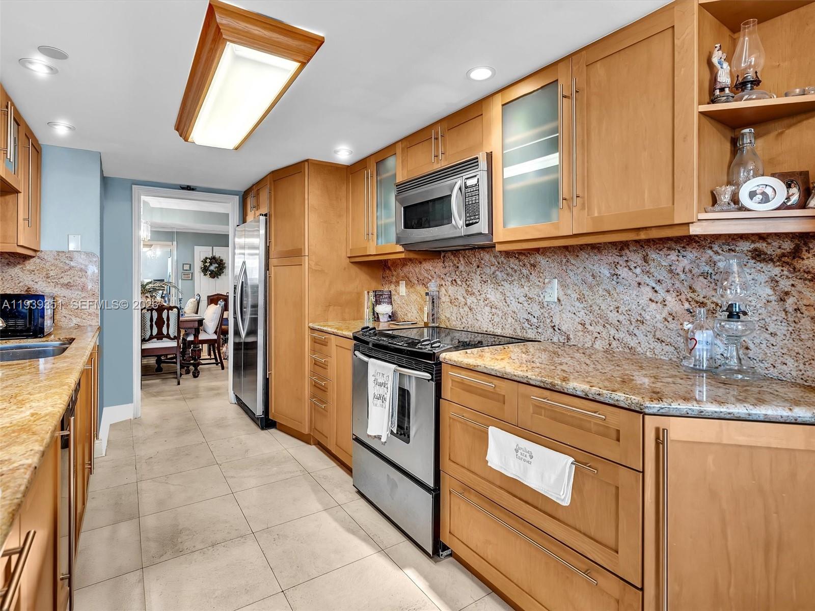 2000 Towerside Terrace, Unit 1806 Miami, FL 33138 - Photo 38 of 58 a kitchen with stainless steel appliances granite countertop a stove a sink and a microwave
