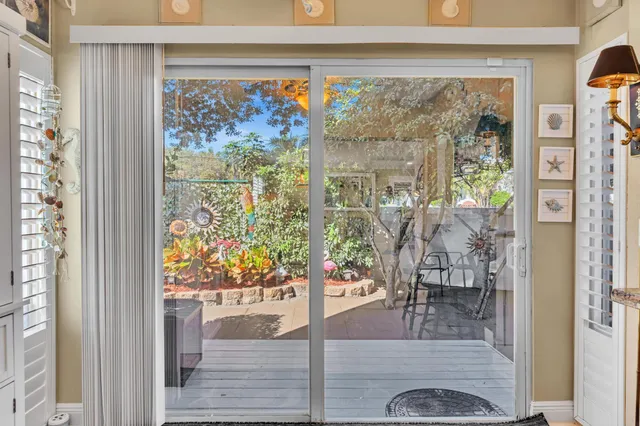 a view of a patio with lawn chairs dining table and chairs under an umbrella