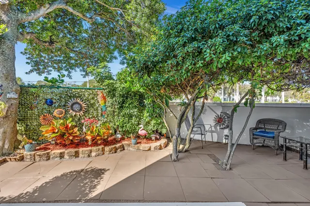 a view of a swimming pool with a lawn chairs under an umbrella next to a yard