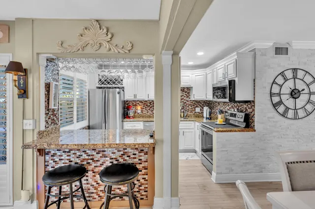a kitchen with granite countertop a stove sink and cabinets