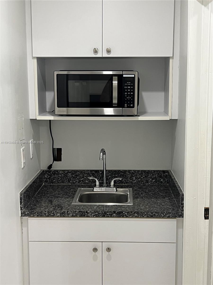14364 Southwest 159th Terrace Miami, FL 33177 - Photo 2 of 7 a kitchen with granite countertop white cabinets and stainless steel appliances