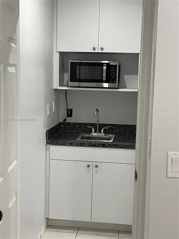a kitchen with granite countertop a stove and a microwave