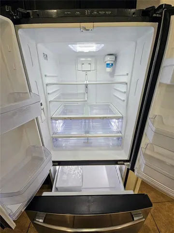 a kitchen with kitchen island granite countertop a refrigerator stove and sink