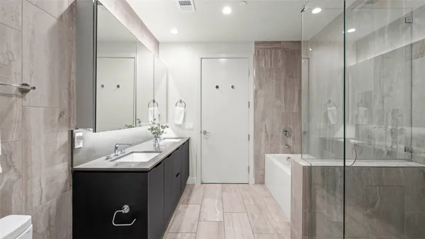 a en suite bathroom with a granite countertop sink and a mirror