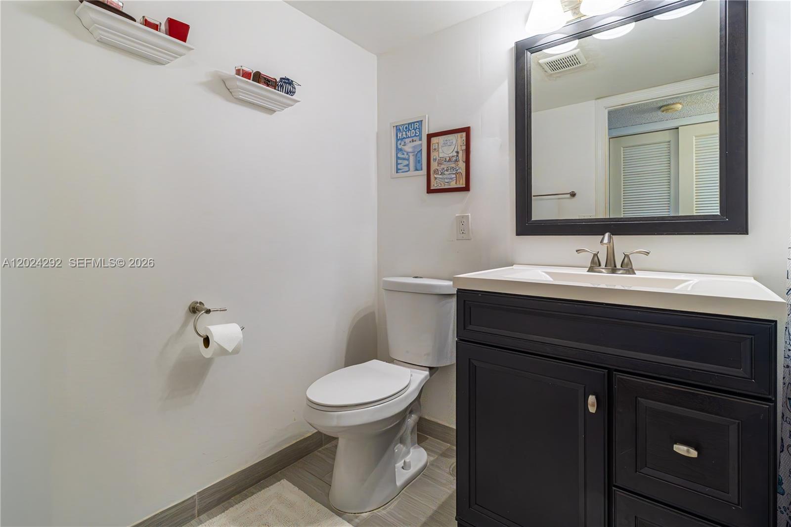 9780 Marina Boulevard, Unit 424 Boca Raton, FL 33428 - Photo 23 of 32 a bathroom with a sink and a toilet