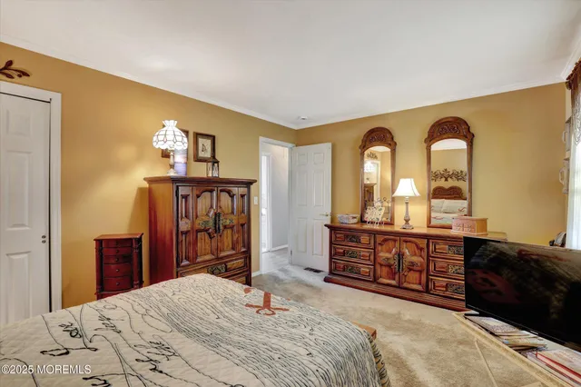 a bedroom with a bed and dresser with mirror