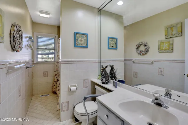 a bathroom with a sink mirror vanity and toilet