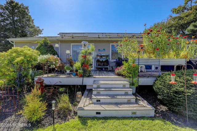a view of a house with potted plants and a bench